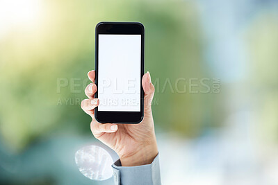 Buy stock photo Cropped shot of an unrecognizable businesswoman holding up her cellphone to display the screen while standing in the office