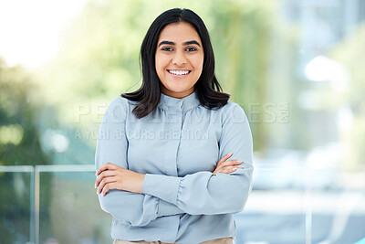 Buy stock photo Cropped portrait of an attractive young businesswoman standing with her arms folded in the office