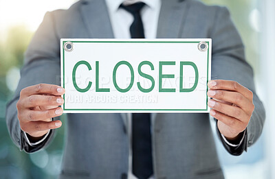 Buy stock photo Cropped shot of an unrecognizable businessman holding up a closed sign while standing in the office