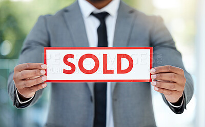 Buy stock photo Cropped shot of an unrecognizable businessman holding up a sold sign while standing in the office