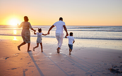 Buy stock photo Shot of a beautiful family bonding while spending a day at the beach together