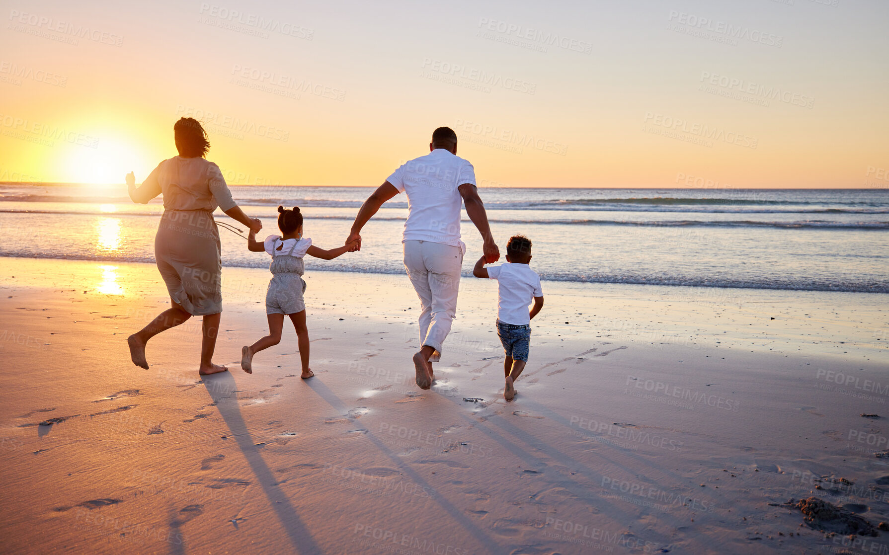 Buy stock photo Shot of a beautiful family bonding while spending a day at the beach together