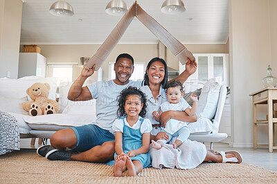 Buy stock photo Shot of a young family sitting on the lounge floor under a cardboard fort together at home
