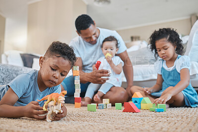 Buy stock photo Shot of a young man playing with kids on the lounge floor