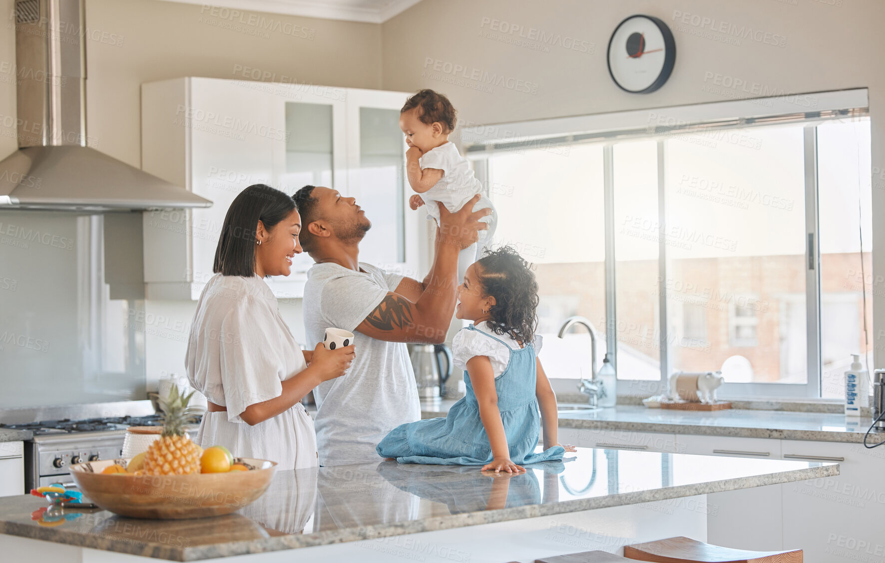 Buy stock photo Shot of a family standing in the kitchen together at home