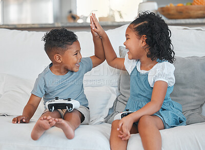 Buy stock photo Shot of a brother and sister playing video games on the sofa at home
