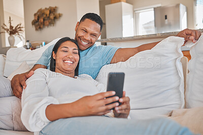 Buy stock photo Happy couple, relax or phone on sofa for media, funny video or excited for travel approval. Man, woman or mobile in home for comedy, humor message or streaming on app or joke notification on platform