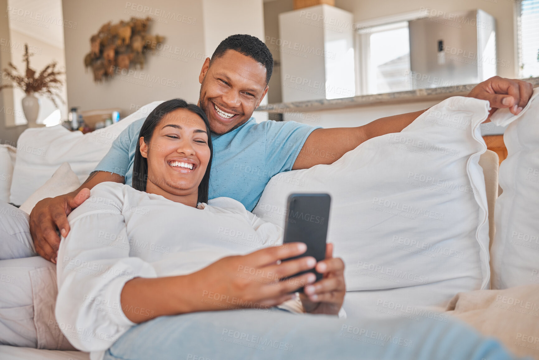 Buy stock photo Happy couple, relax or phone on sofa for media, funny video or excited for travel approval. Man, woman or mobile in home for comedy, humor message or streaming on app or joke notification on platform