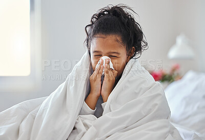Buy stock photo Shot of a little girl blowing her nose and looking sick in bed