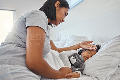Buy stock photo Shot of a woman taking her young daughters temperature at home