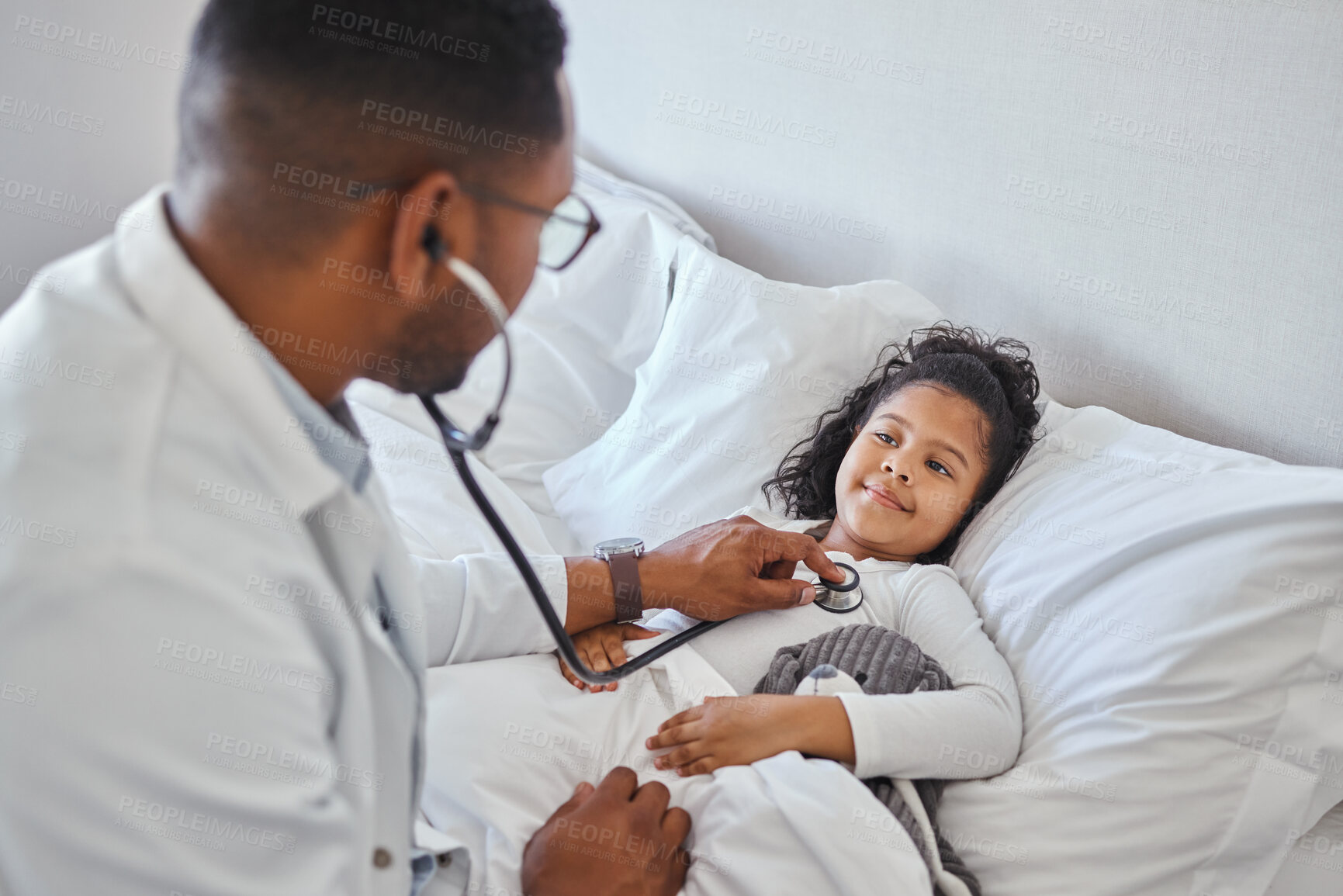 Buy stock photo Shot of a male doctor visiting a little girl at home