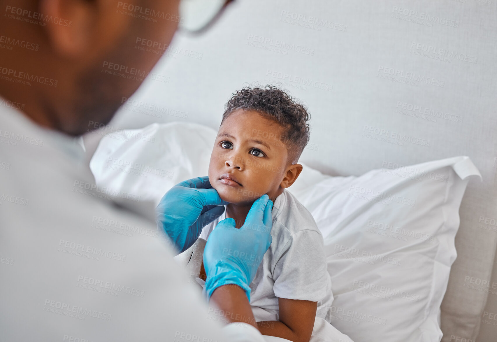 Buy stock photo Shot of a male doctor visiting a little boy at home