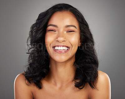 Buy stock photo Cropped portrait of an attractive young woman posing in studio against a grey background