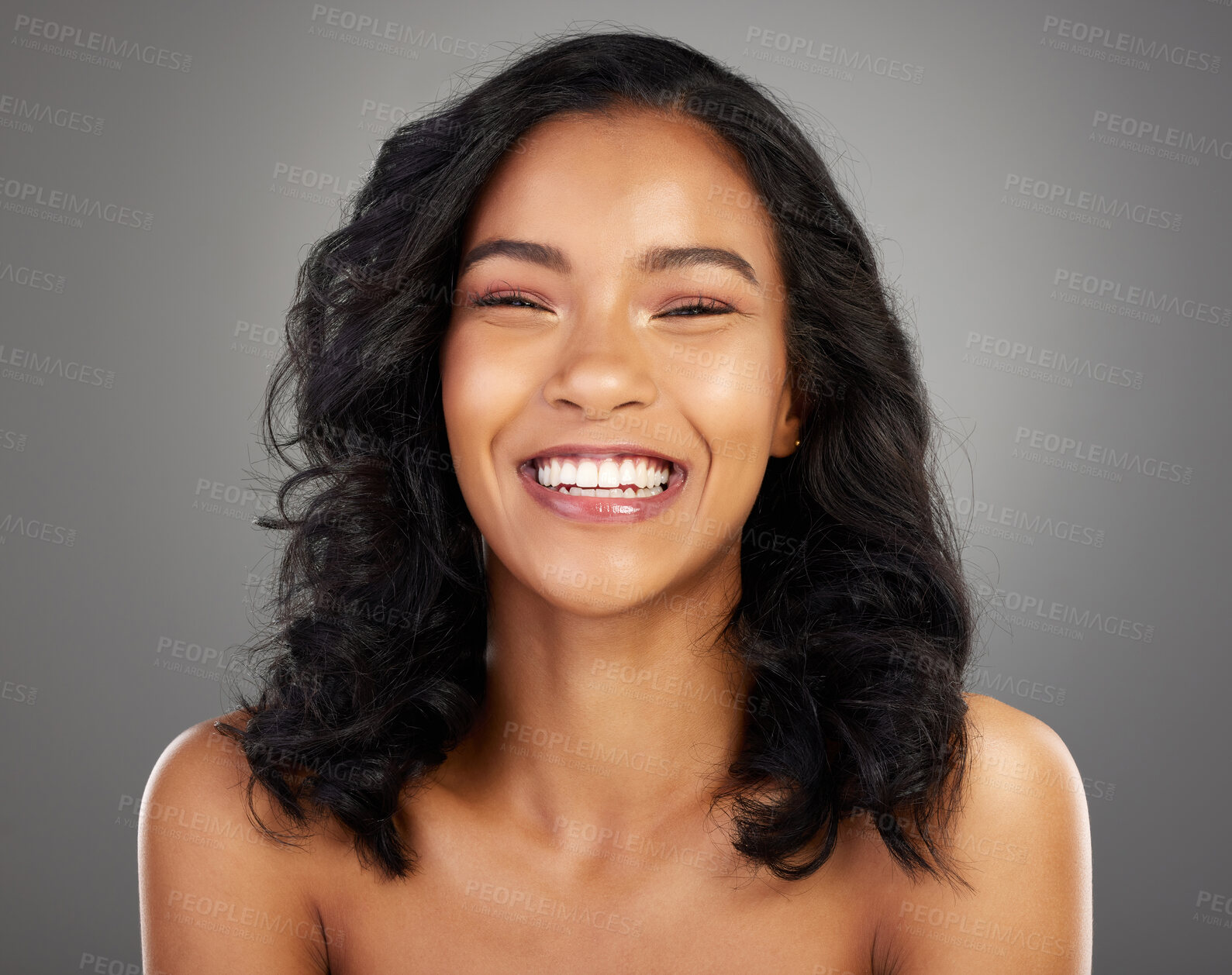 Buy stock photo Cropped portrait of an attractive young woman posing in studio against a grey background