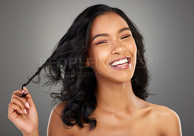 Buy stock photo Cropped portrait of an attractive young woman posing in studio against a grey background