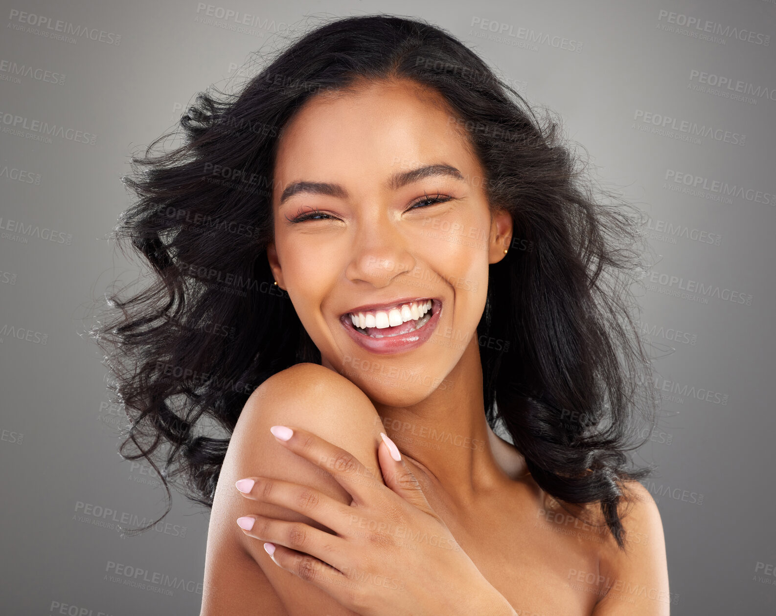 Buy stock photo Cropped portrait of an attractive young woman posing in studio against a grey background