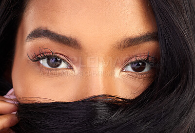 Buy stock photo Closeup portrait of an attractive young woman posing with her hair over her face in studio