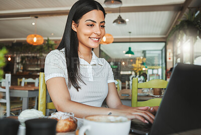 Buy stock photo Shot of a young businesswoman working on her laptop in a coffee shop