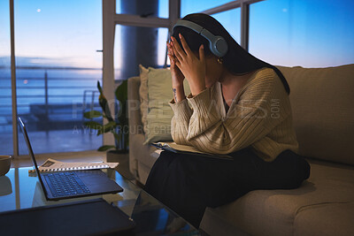 Buy stock photo Remote work, laptop and woman with headache at night for mistake, fatigue or overtime pressure. Home, headphones and overwhelmed freelancer with stress in living room for project, research or burnout