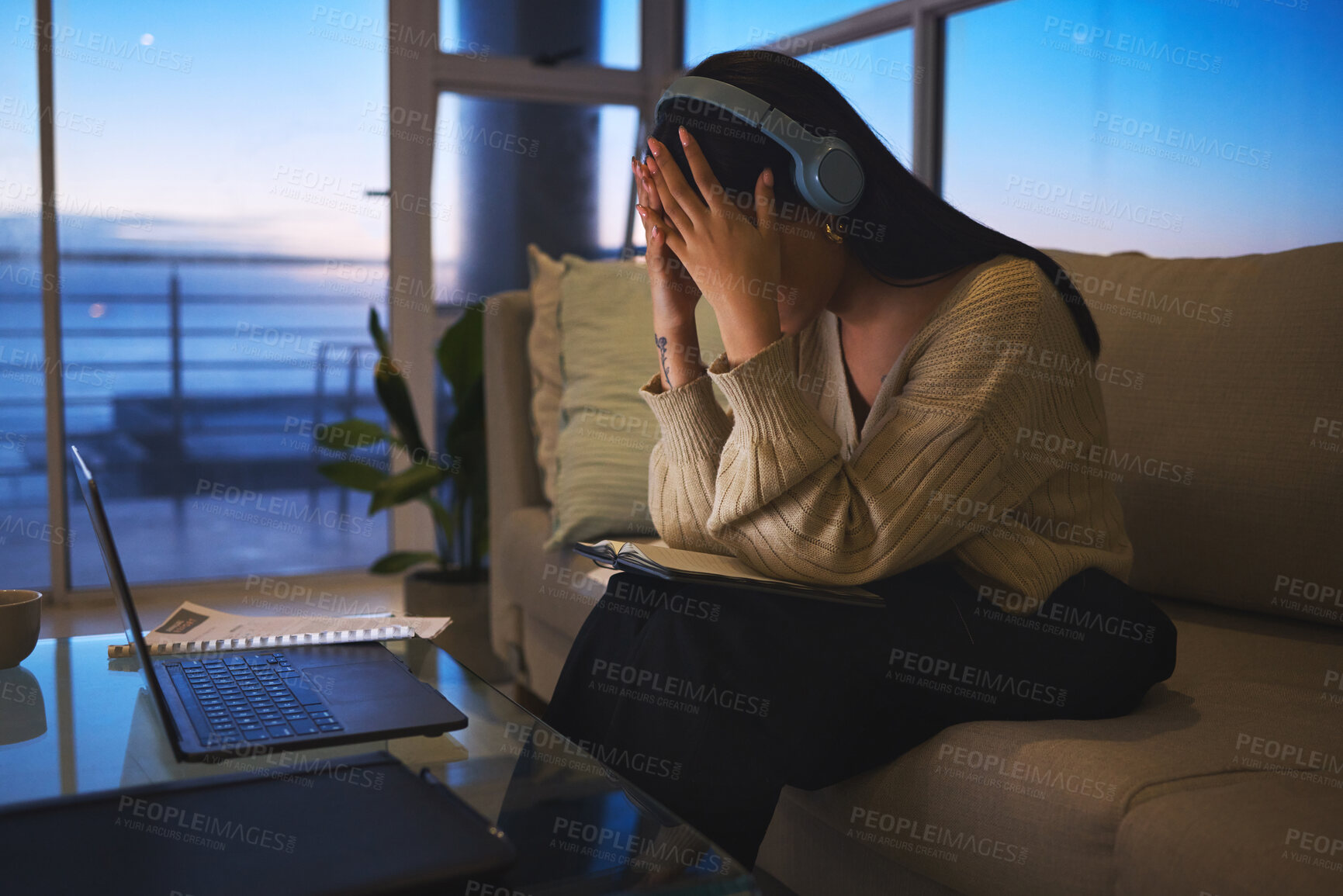 Buy stock photo Remote work, laptop and woman with headache at night for mistake, fatigue or overtime pressure. Home, headphones and overwhelmed freelancer with stress in living room for project, research or burnout