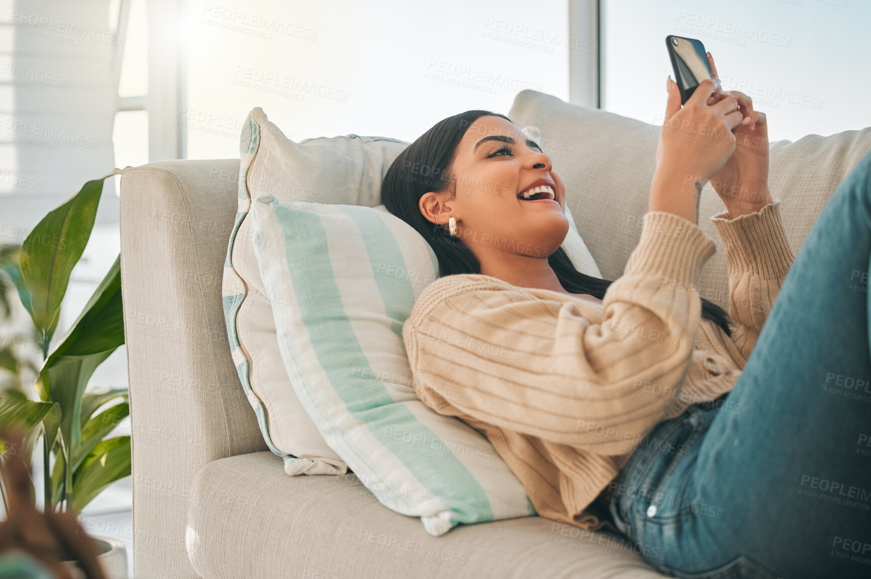 Buy stock photo Happy, laugh and woman with phone on sofa for social media, online chatting and funny website. Relax, home and girl on smartphone for communication, networking and internet in living room on weekend