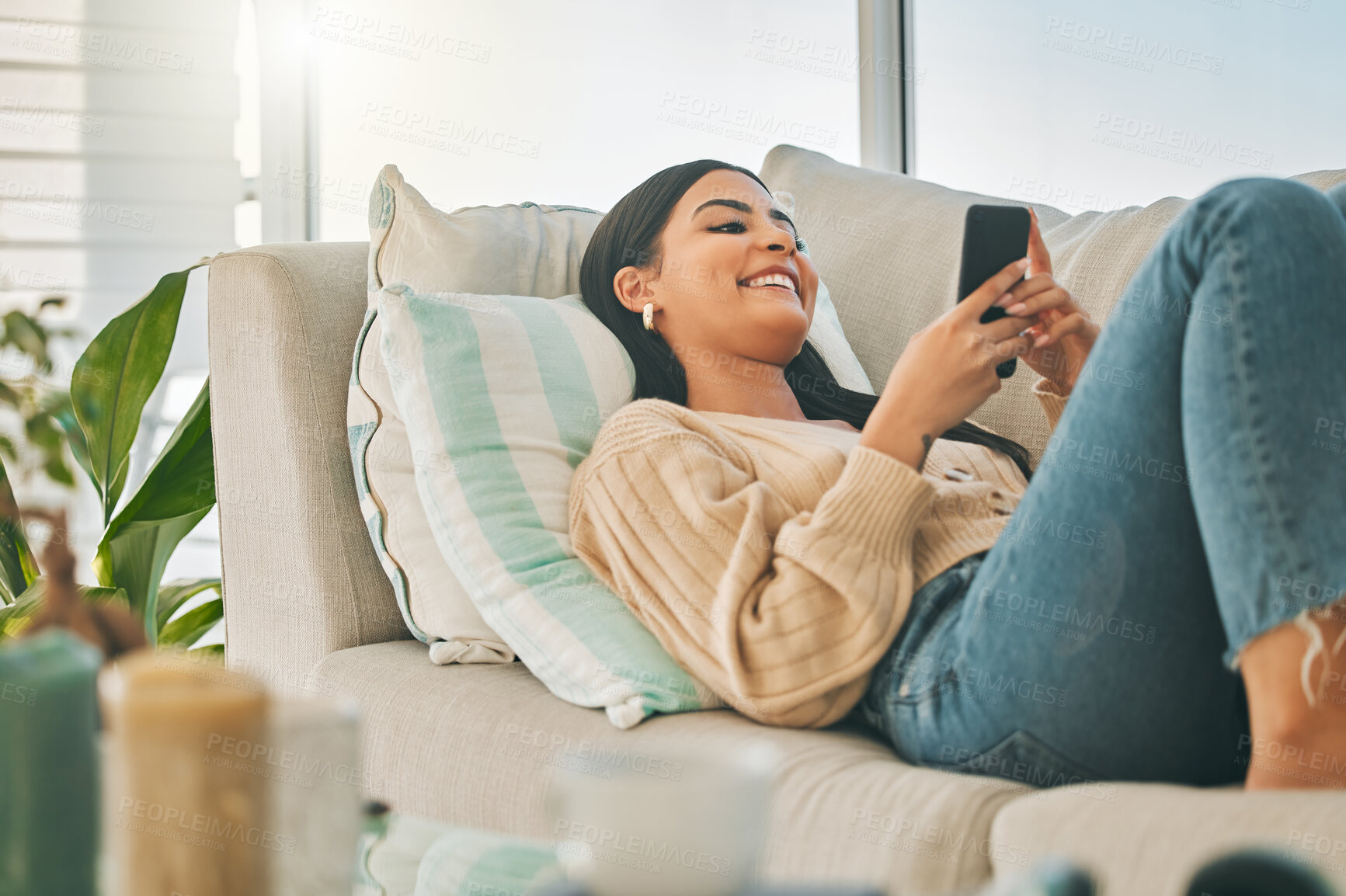 Buy stock photo Happy, relax and woman with phone on sofa for social media, online chatting and funny website. Chill, home and girl on smartphone for communication, networking and internet in living room on weekend