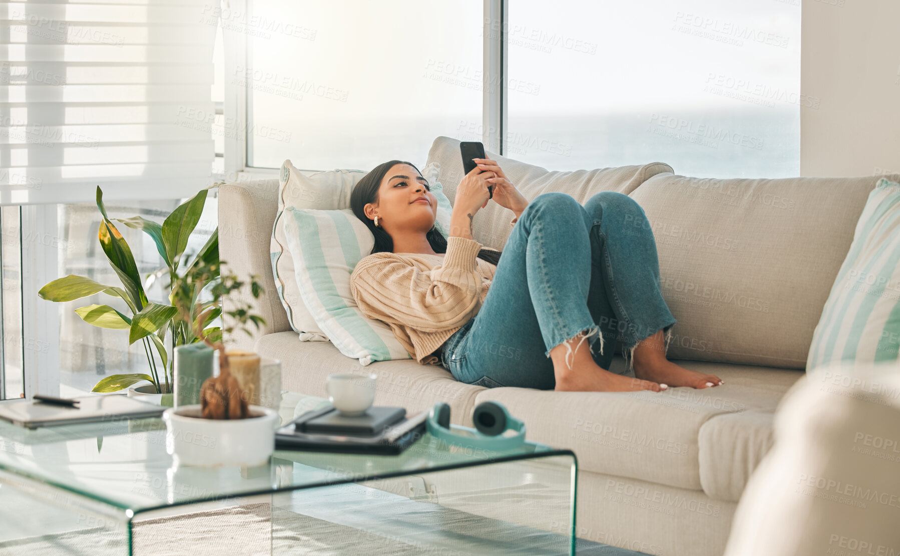 Buy stock photo Home, relax and woman with phone on sofa for social media, online chatting and reading message. Happy, couch and girl on smartphone for communication, website and internet in living room on weekend