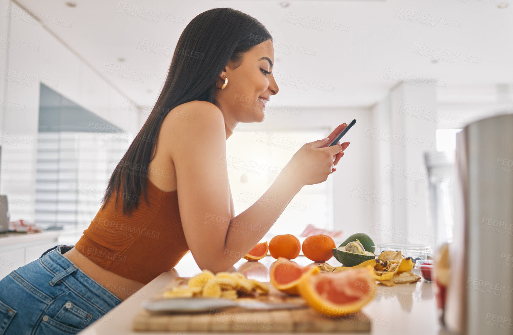 Buy stock photo Woman, phone and cooking breakfast in home, typing and fruit for mineral liquid in kitchen. Female person, nutrition and online for social media blog on diet, smoothie cocktail and vegan website