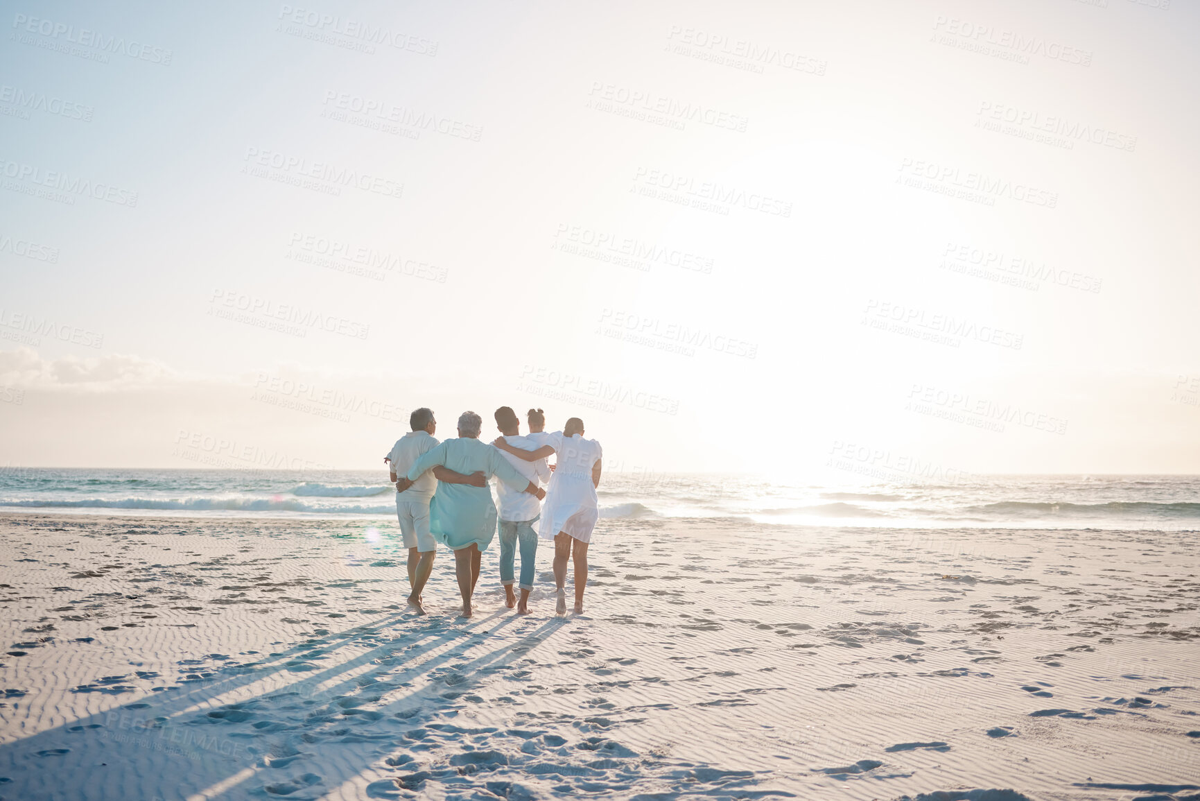 Buy stock photo Big family, hug and walking on beach with mockup space for holiday, weekend or vacation. Grandparents, parents and kids on a ocean walk together by the coast for fun bonding or quality time in nature