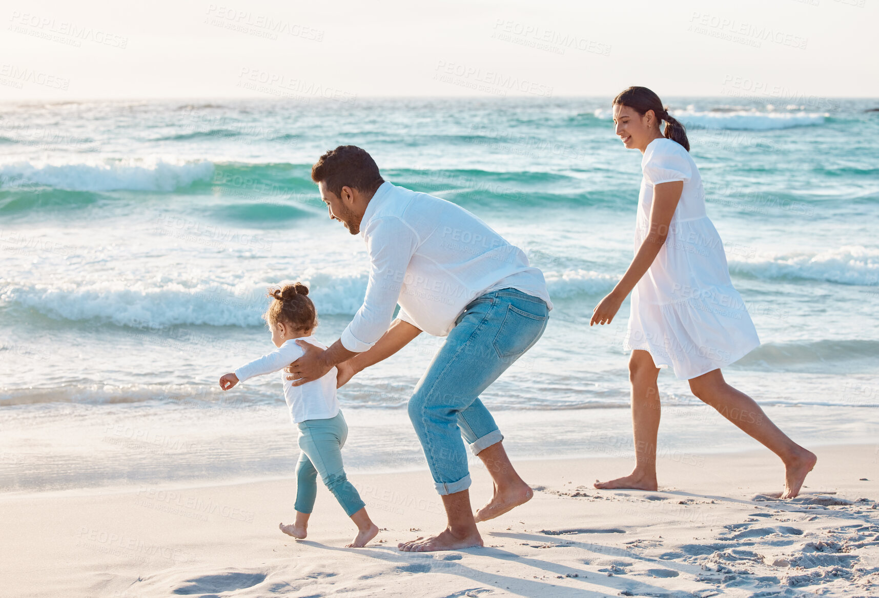 Buy stock photo Shot of a couple spending the day at the beach with their daughter