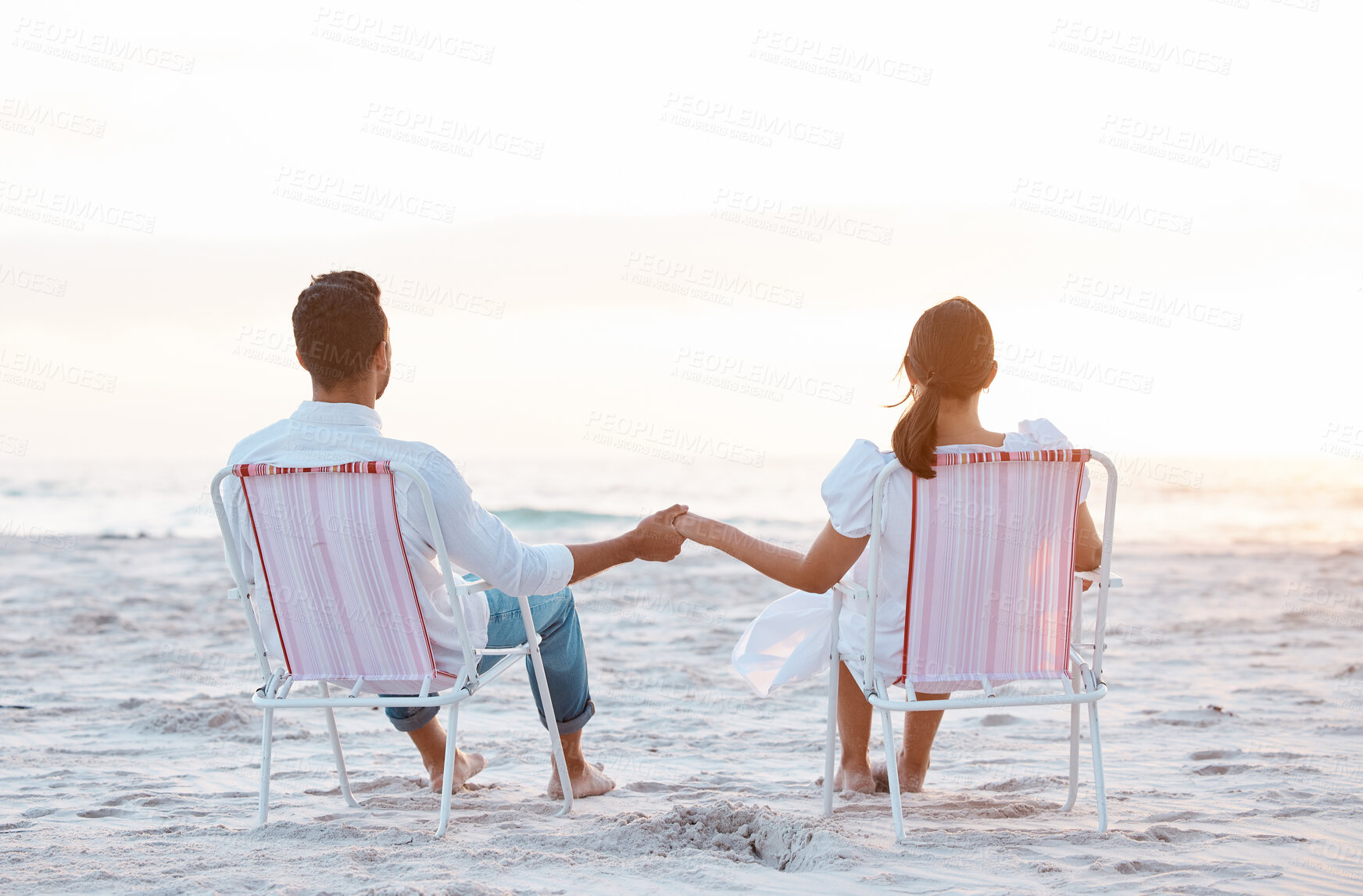 Buy stock photo Couple, beach chair and holding hands on vacation, love and outdoor at sunset, back and bonding in summer. People, man and woman with mock up space, relax and view on holiday by ocean in Indonesia