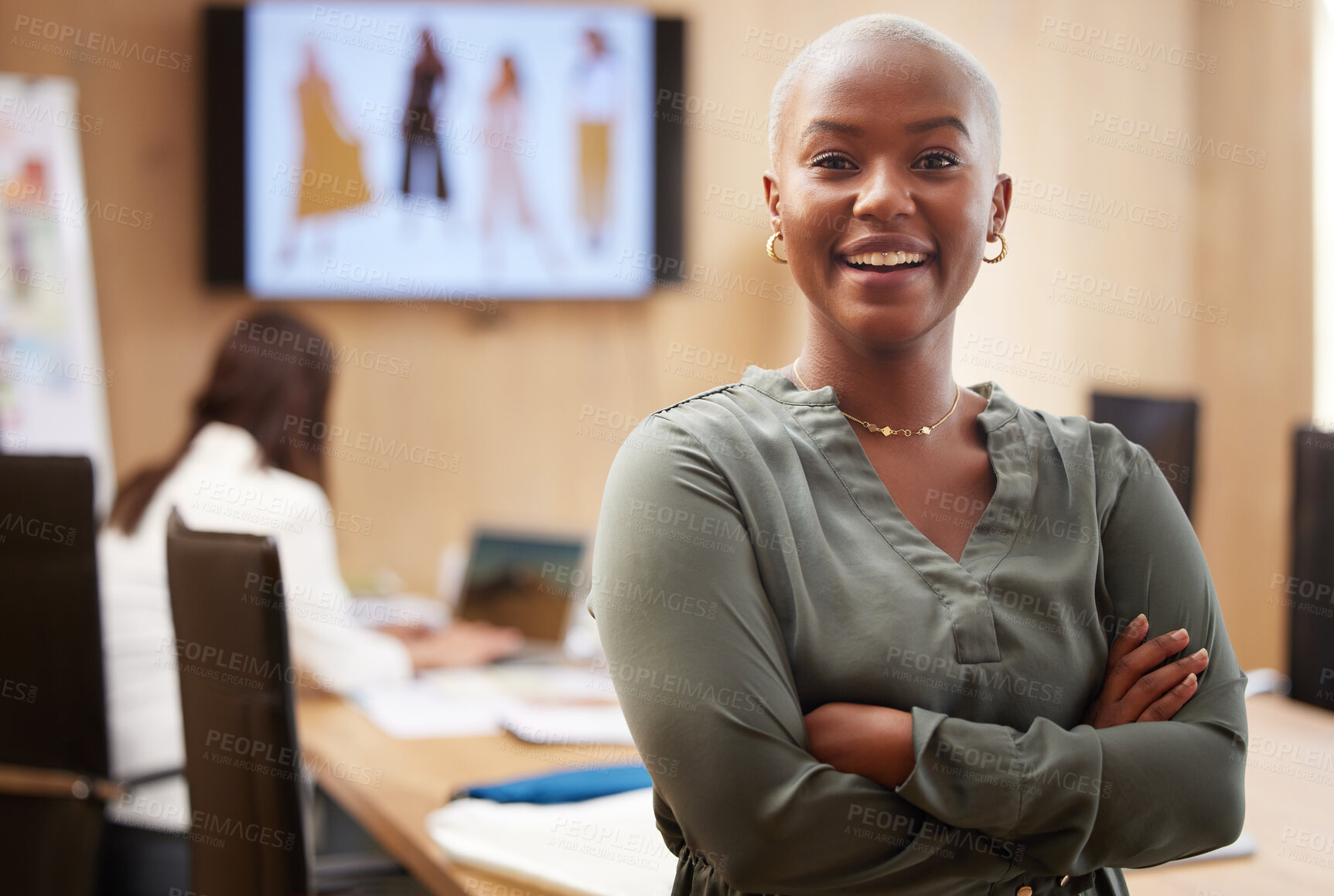 Buy stock photo Shot of a young businesswoman standing with her arms crossed in an office at work