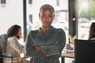 Buy stock photo Shot of a young businesswoman standing with her arms crossed at work