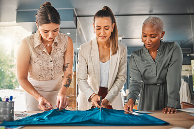 Buy stock photo Shot of a group of young female designers cutting material at a boutique