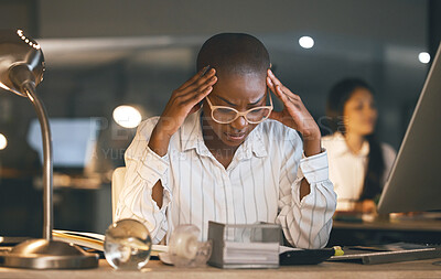 Buy stock photo Shot of a young businesswoman suffering from a headache while working late in a modern office