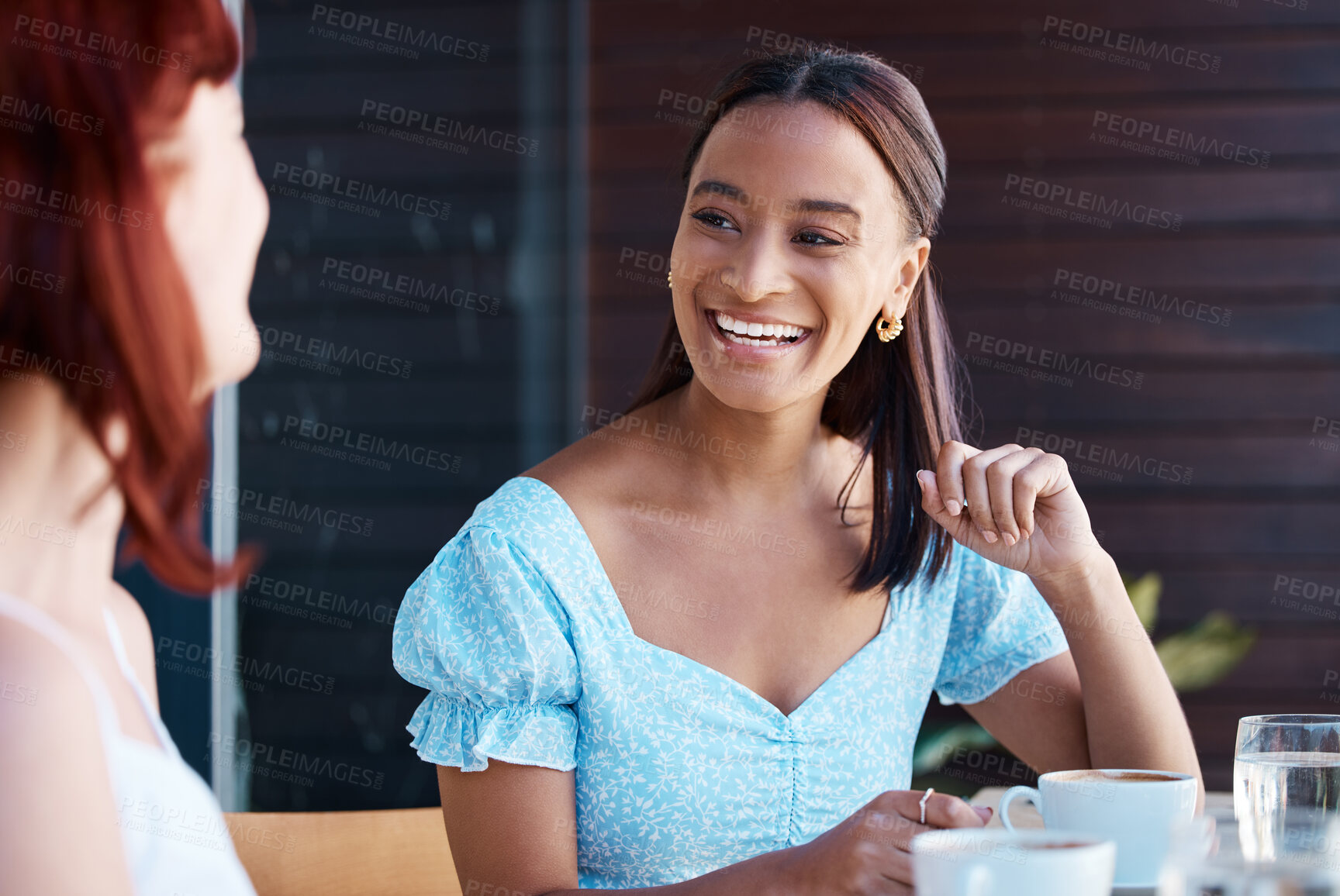 Buy stock photo Shot of two young female friends catching up at a cafe