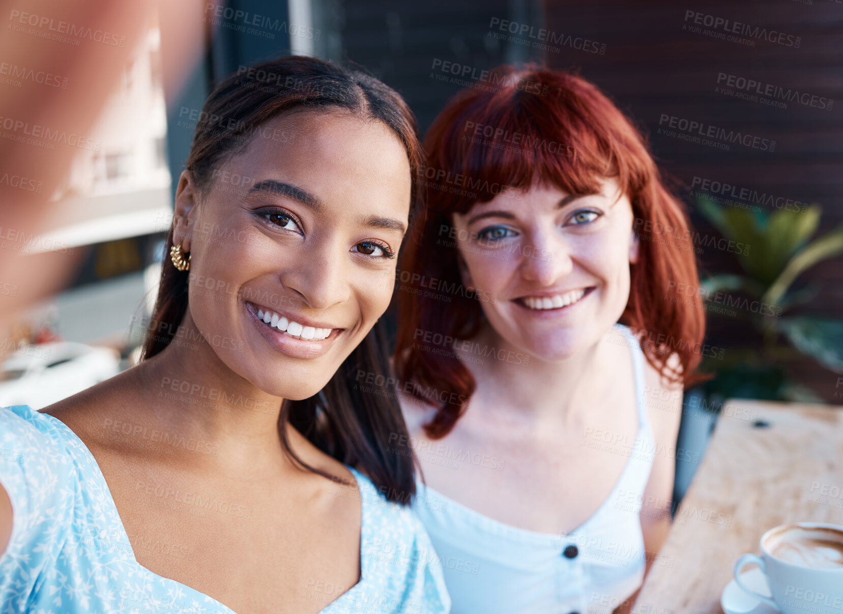 Buy stock photo Shot of two young female friends taking a selfie at a cafe