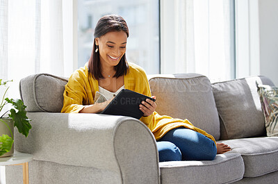 Buy stock photo Shot of a young woman using a digital tablet at home