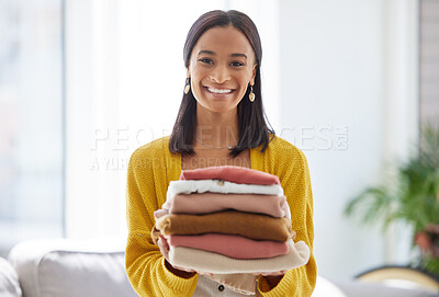 Buy stock photo Shot of a young woman doing laundry at home