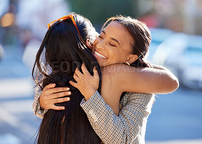 Buy stock photo Cropped shot of two attractive young girlfriends hugging while out on the town
