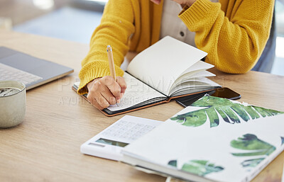 Buy stock photo Shot of an unrecognizable businesswoman writing in a notebook at home