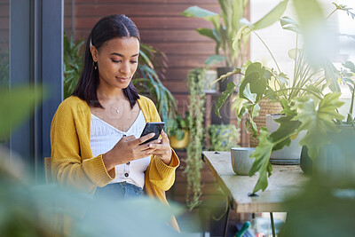 Buy stock photo Woman, typing or browsing with phone at cafe for online connection, network or social media. Female person, journalist or freelancer on mobile smartphone for communication at eco friendly coffee shop