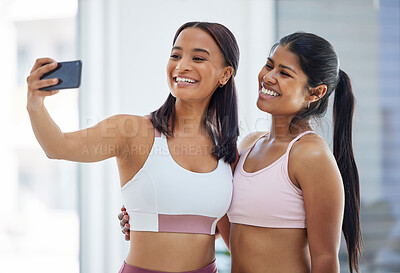 Buy stock photo Shot of two sporty young woman taking selfies in a yoga studio