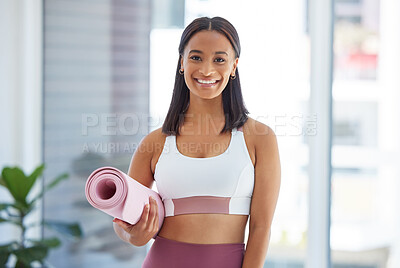 Buy stock photo Portrait of a sporty young woman holding an exercise mat in a yoga studio