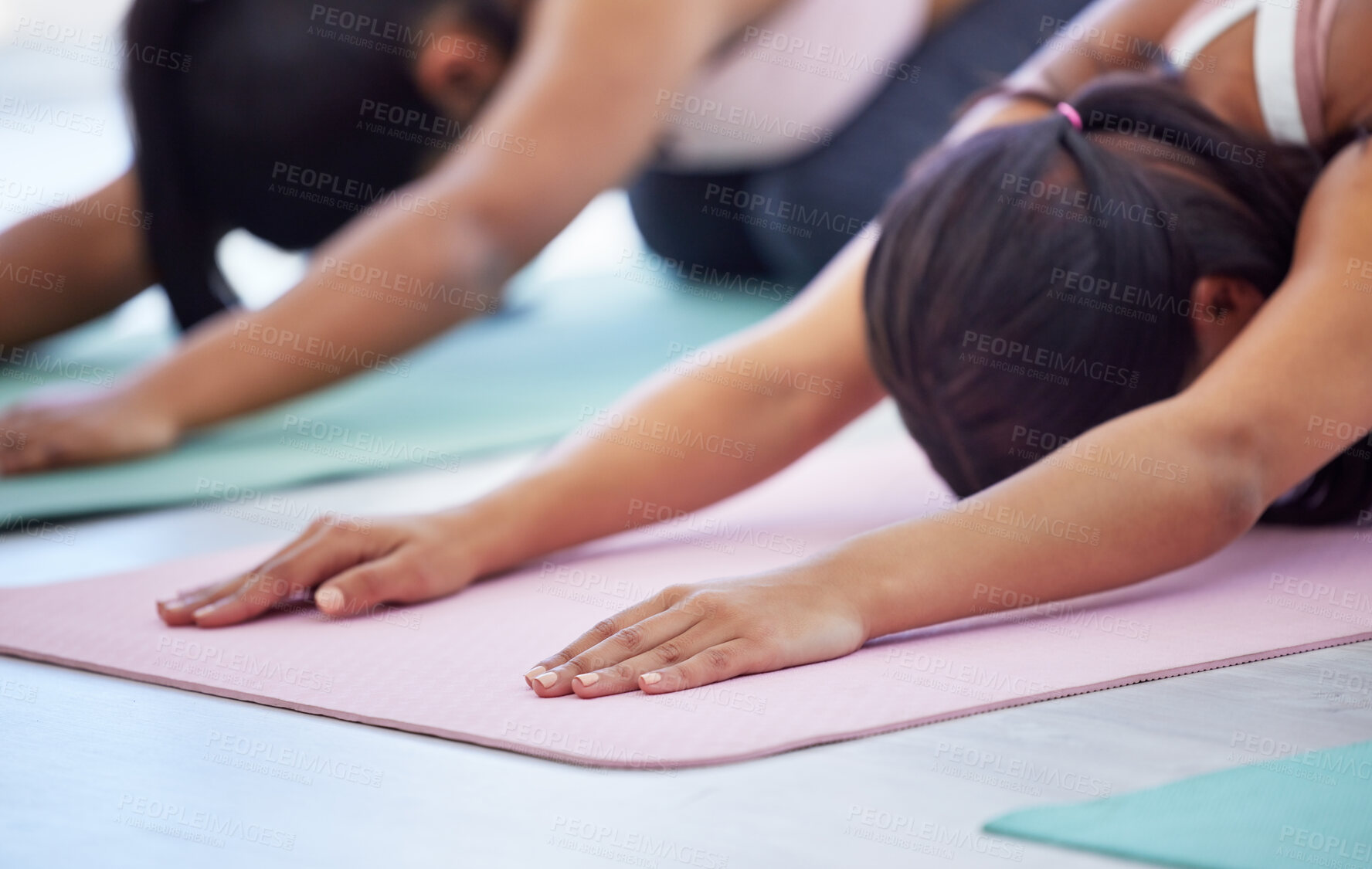 Buy stock photo Closeup shot of a group of sporty young women doing child's pose while exercising in a yoga studio