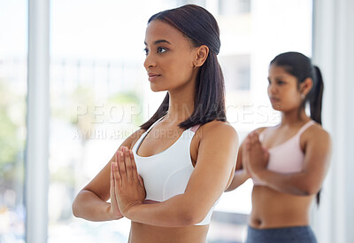 Buy stock photo Shot of a sporty young woman meditating while exercising in a yoga studio