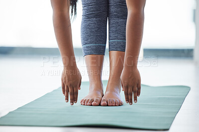 Buy stock photo Closeup shot of an unrecognisable woman touching her toes while exercising in a yoga studio