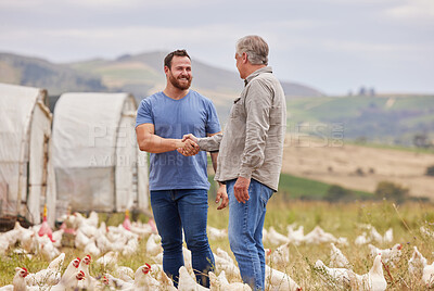 Buy stock photo Shot of two men shaking hands while working together on a poultry farm