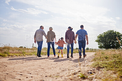 Buy stock photo Shot of a multi-generational family walking together on a farm