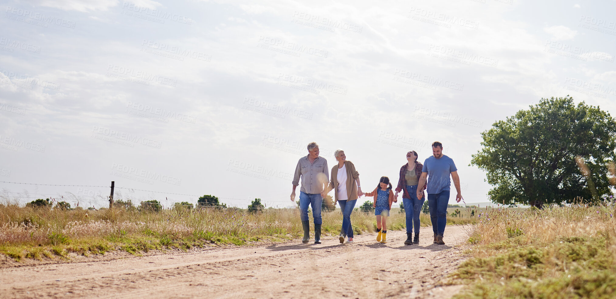 Buy stock photo Love, happy family walking holding hands and on a farm with blue sky. Support or care, happiness or agriculture and people walk outdoors by countryside or rural environment together with generation